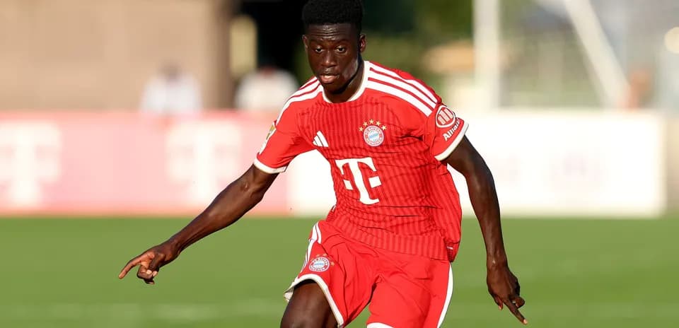 Player in red kit dribbling during training session