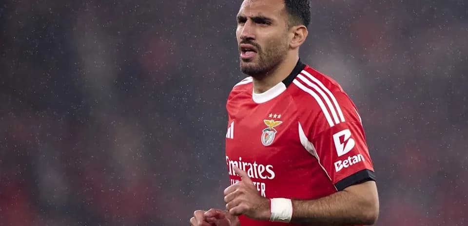 Benfica player running in the rain during match