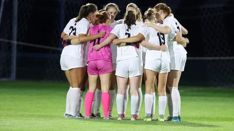 Soccer team huddled together before match