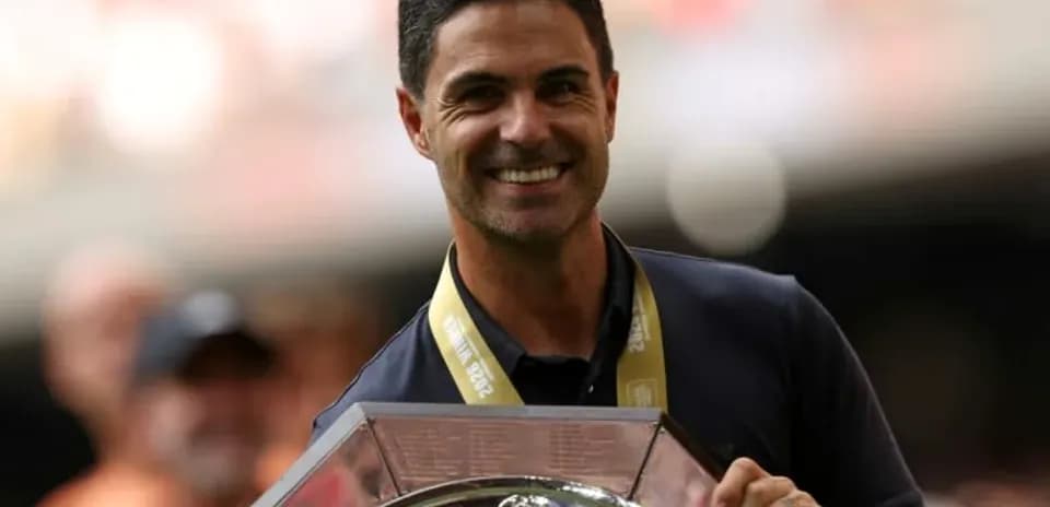 Man holding trophy with celebratory crowd in background