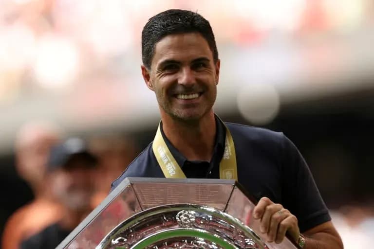 Man holding trophy with celebratory crowd in background