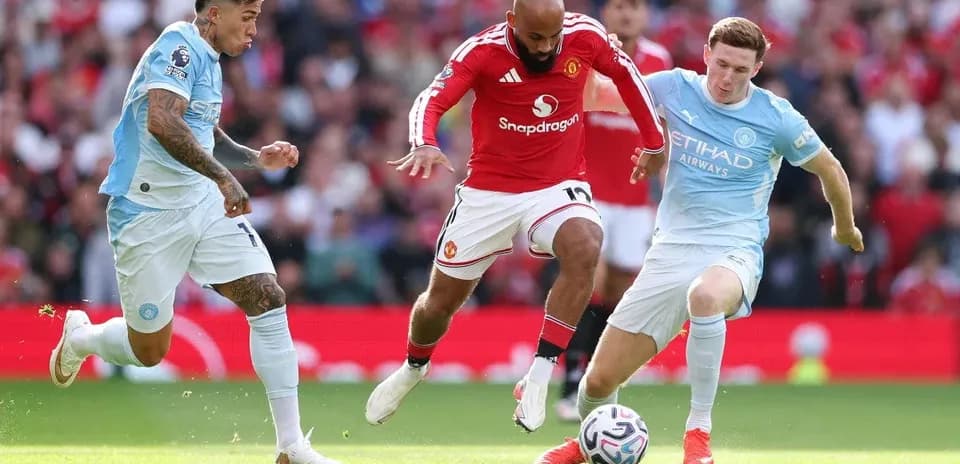 Players from Manchester United and Manchester City contesting for the ball