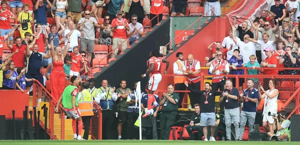 Fans celebrating a goal in the stadium stands
