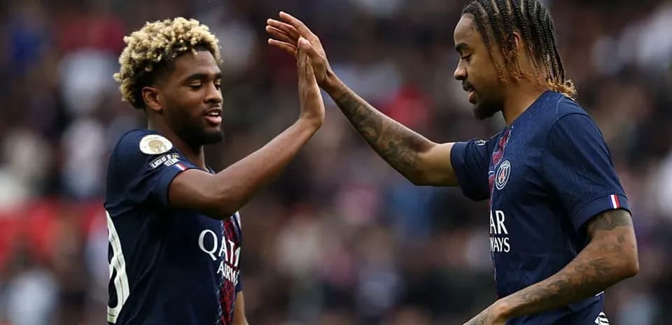 Two PSG players high-fiving on the field