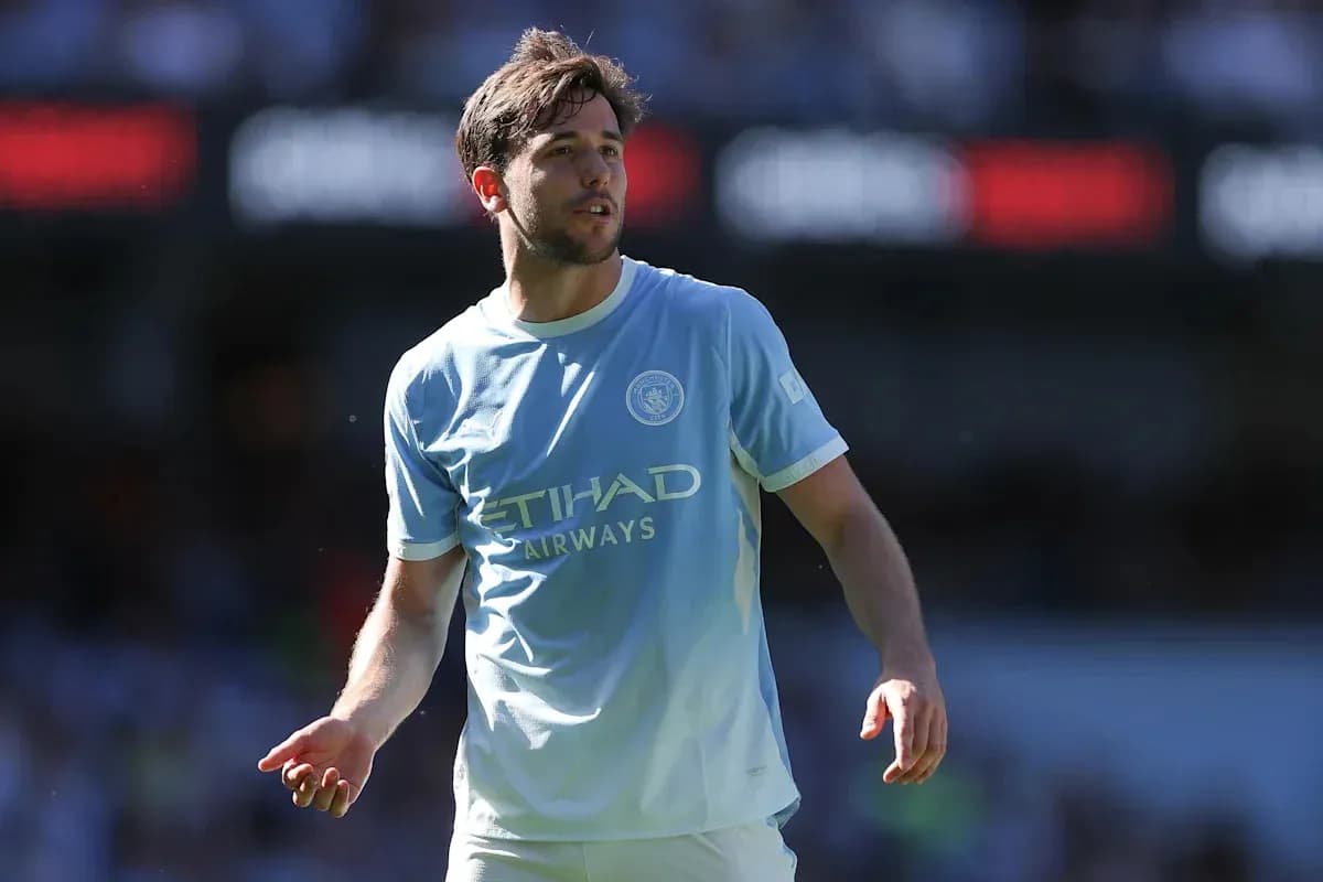 Player in light blue Manchester City kit on pitch