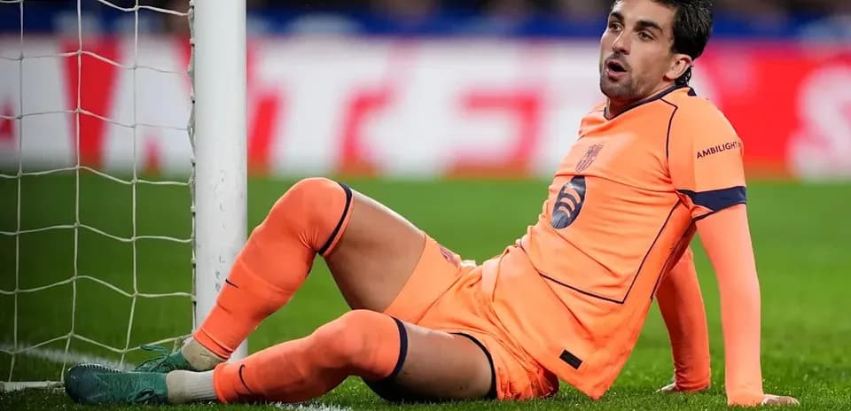 Goalkeeper sitting on the ground near goalpost