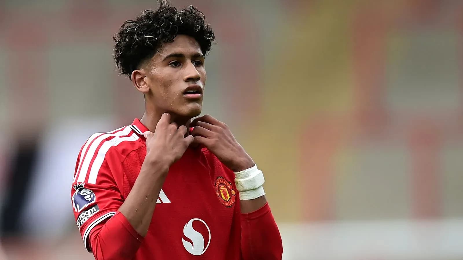 Young player adjusting his collar during match