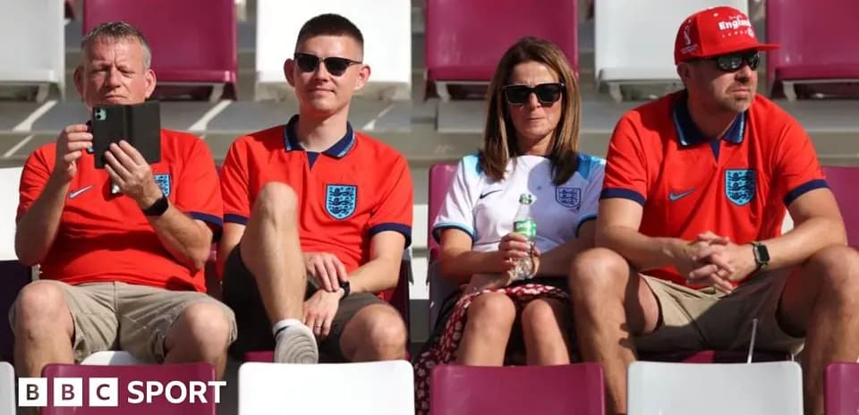 Fans in England shirts sitting in stadium seats