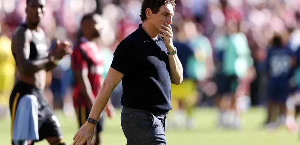 Coach walking off the field after a match