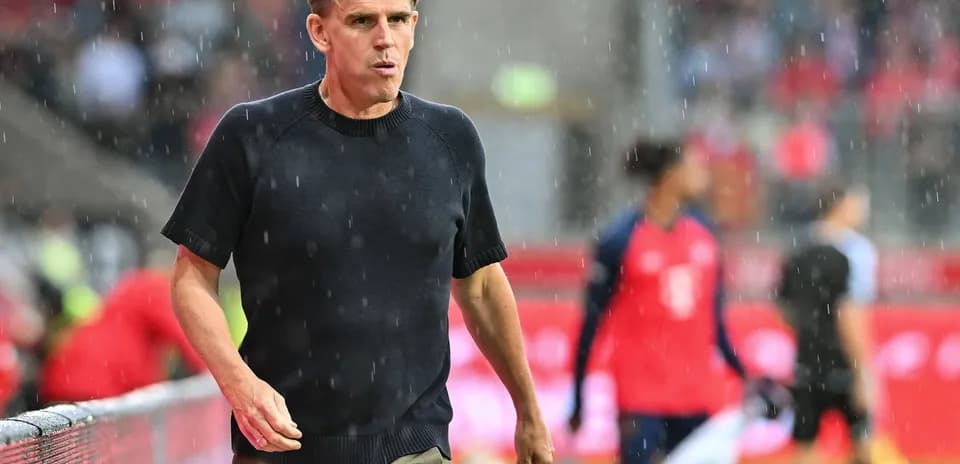 Coach walking along the sideline in the rain