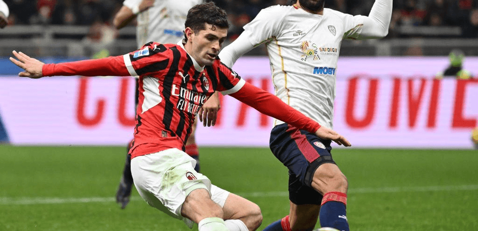 AC Milan player challenging Cagliari opponent during match