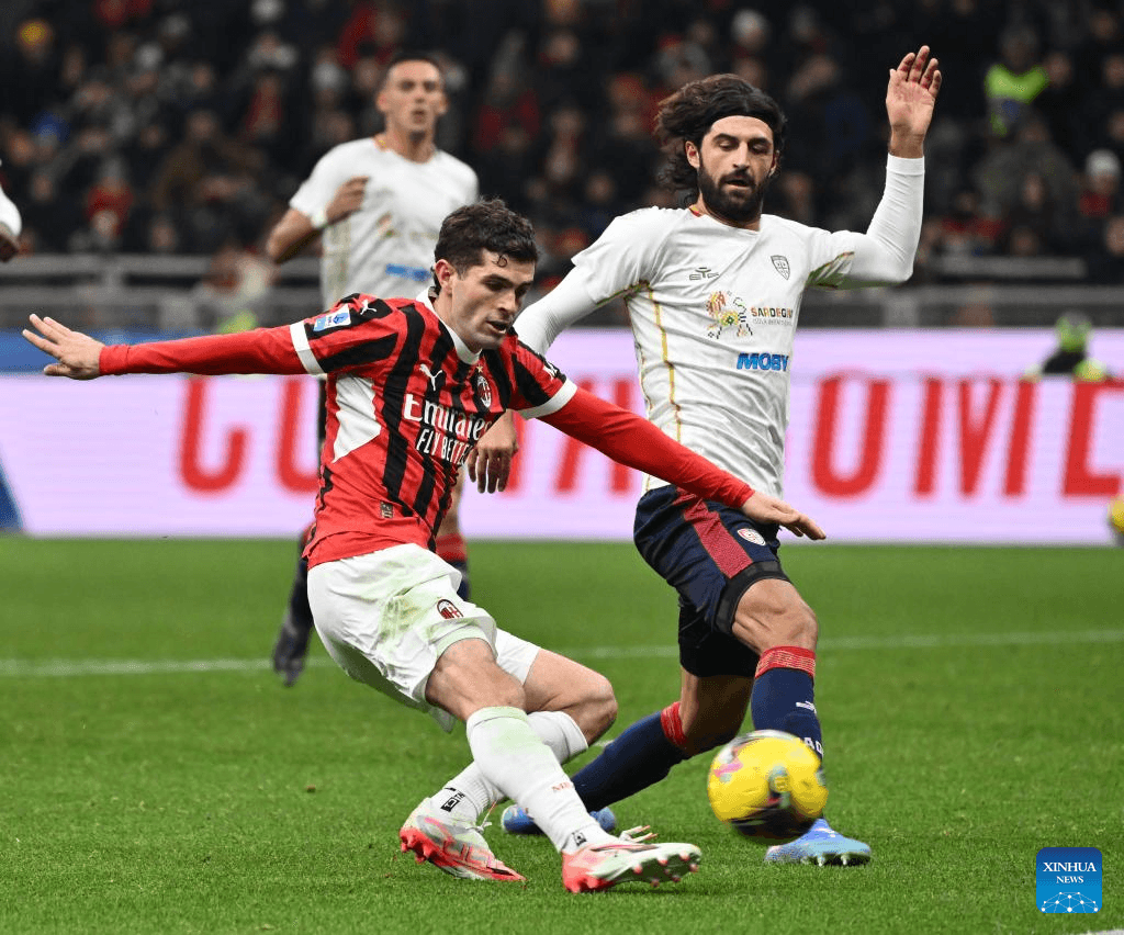 AC Milan player challenging Cagliari opponent during match