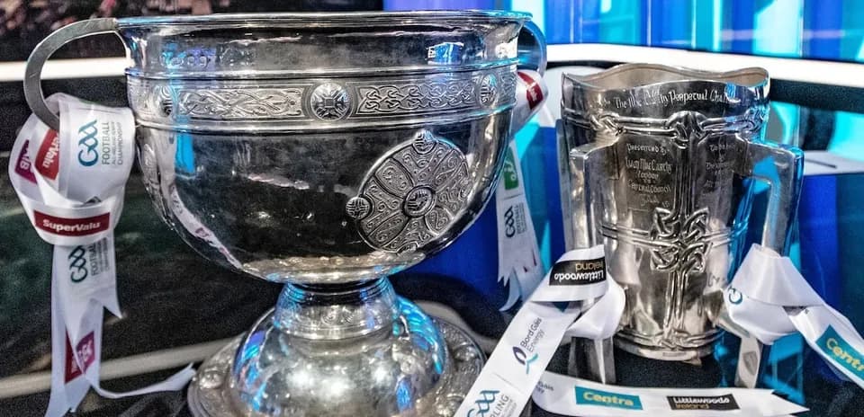 GAA trophies displayed with sponsor ribbons