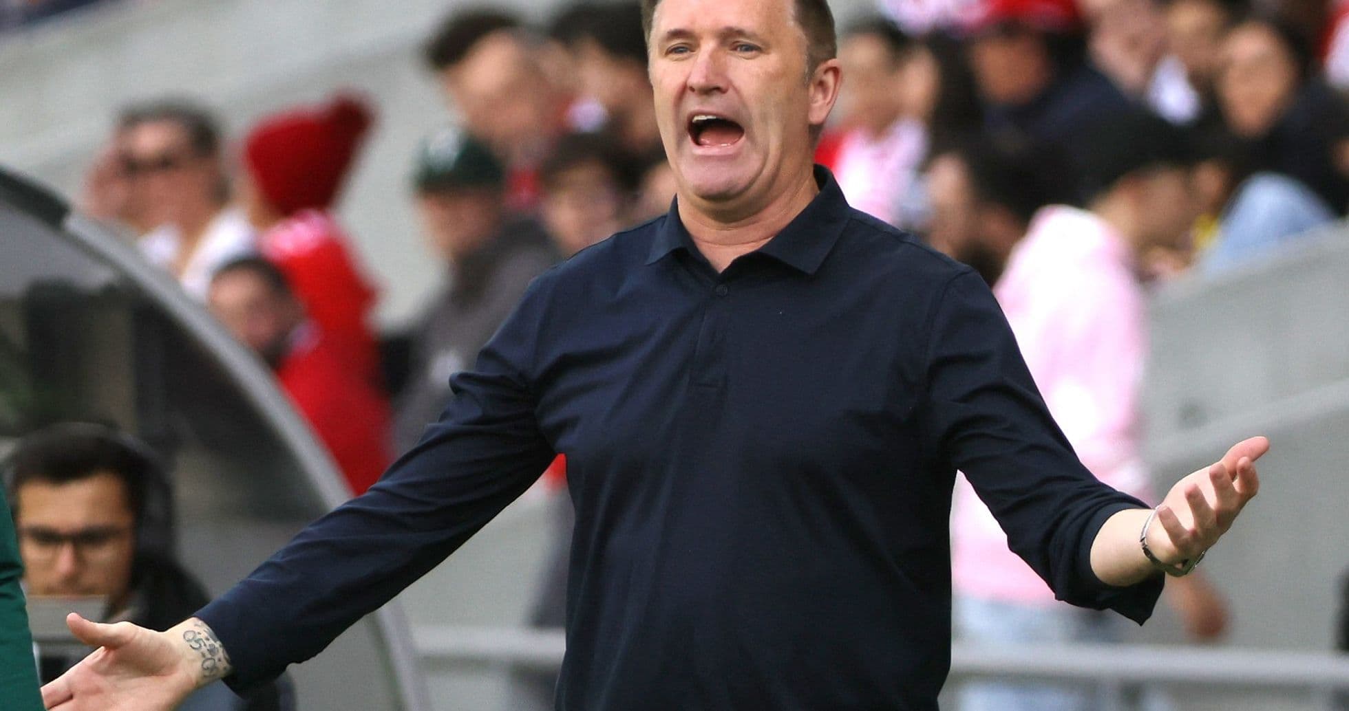Coach gesturing animatedly during a match