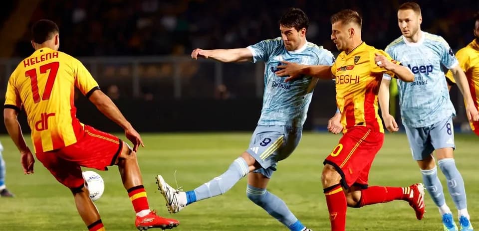 Lecce player challenges Juventus forward for the ball