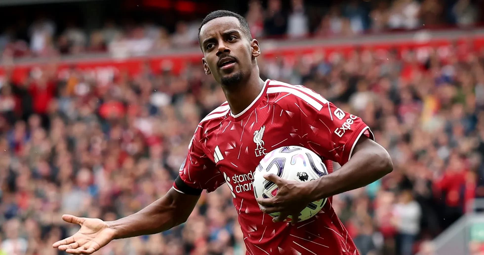 Player in Liverpool jersey holding a football