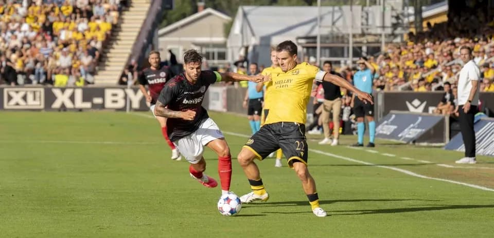 Lincoln Red Imps player challenging Mjallby AIF player