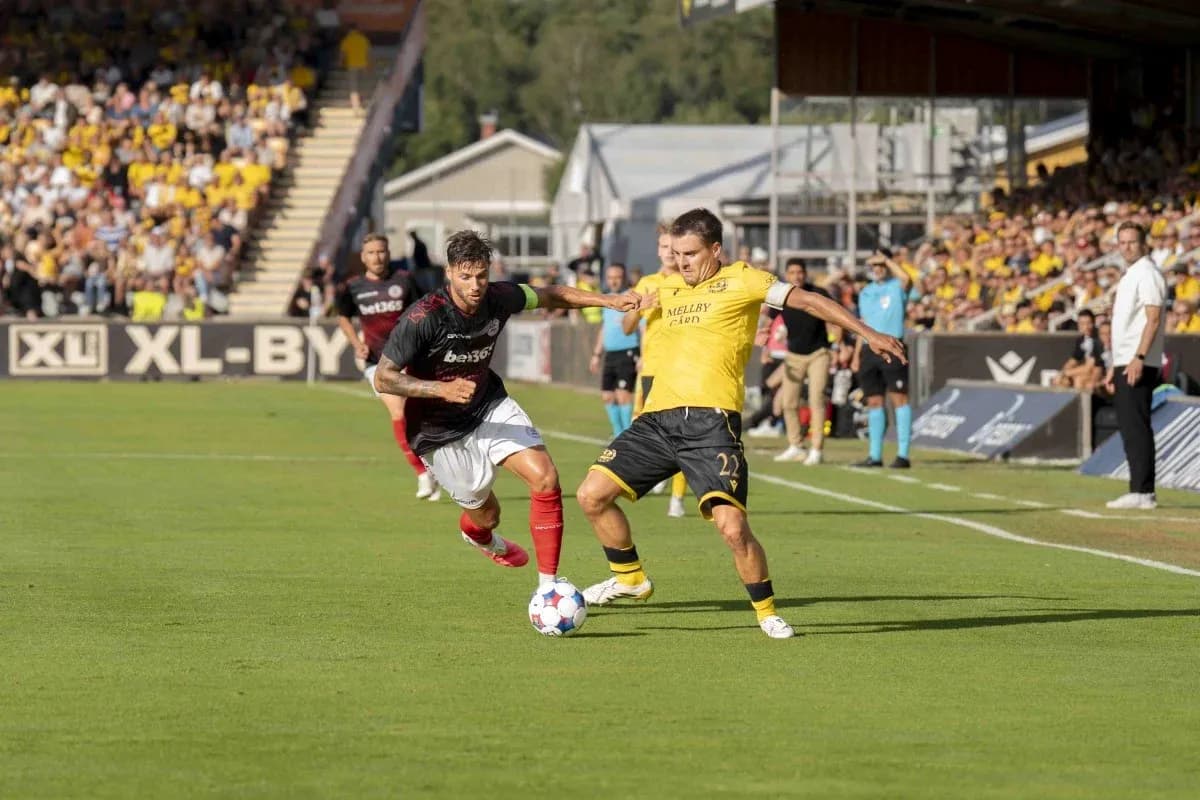 Lincoln Red Imps player challenging Mjallby AIF player