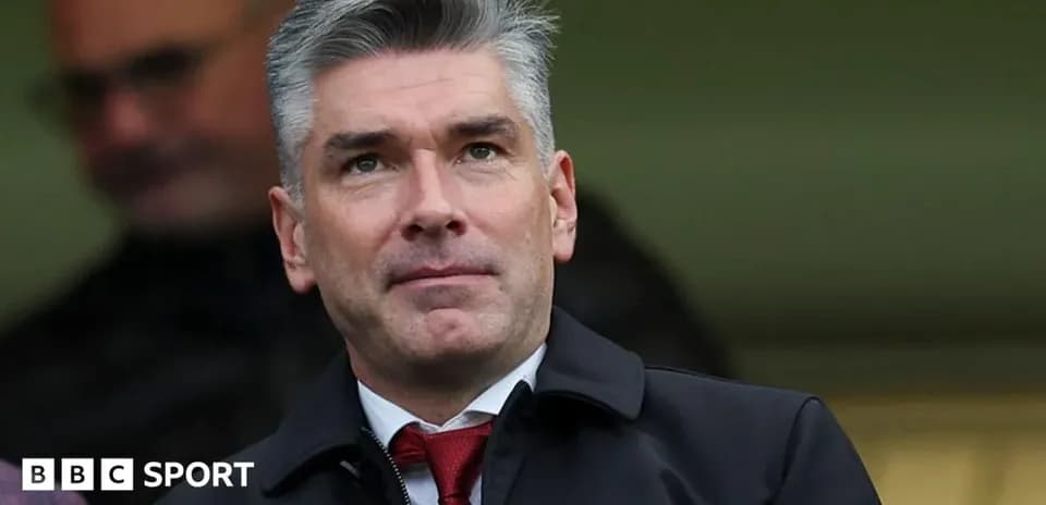 Man in suit observing from stands at a match