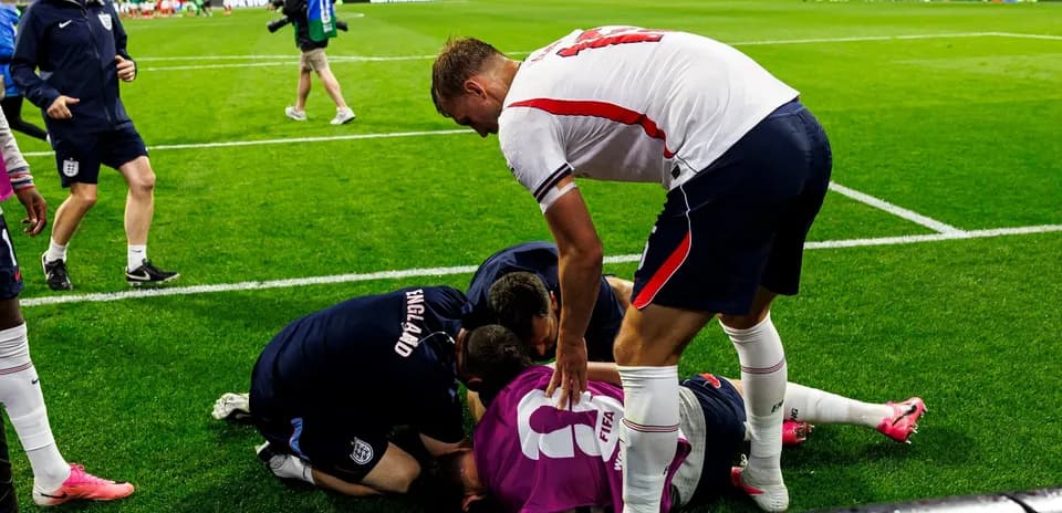 Players and staff attending to injured goalkeeper on field