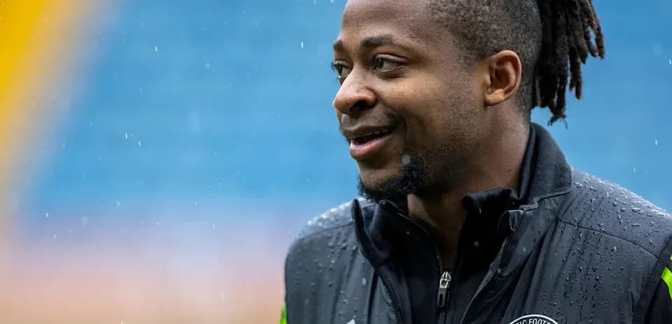 Player in training gear smiling during rain
