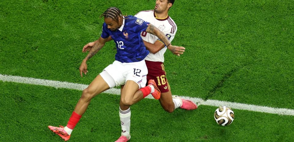 Two players battling for the ball on field