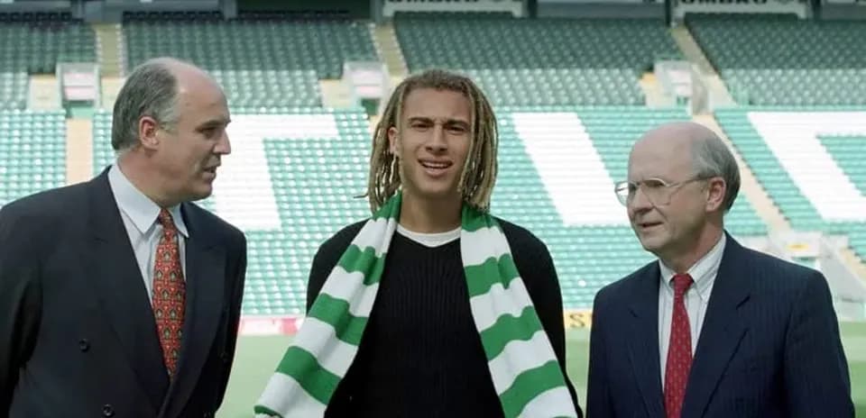 Player holding scarf with two officials at stadium