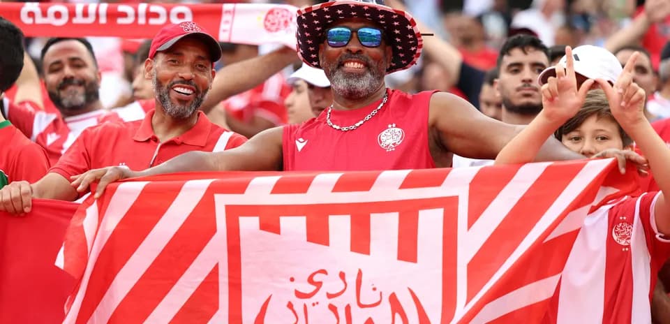 Fans celebrating with a club flag in the stands
