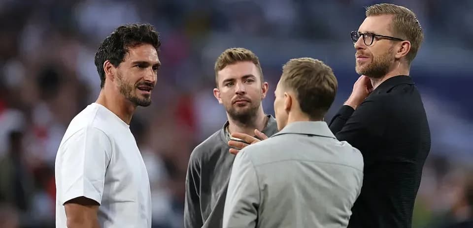 Four men conversing on a sports field