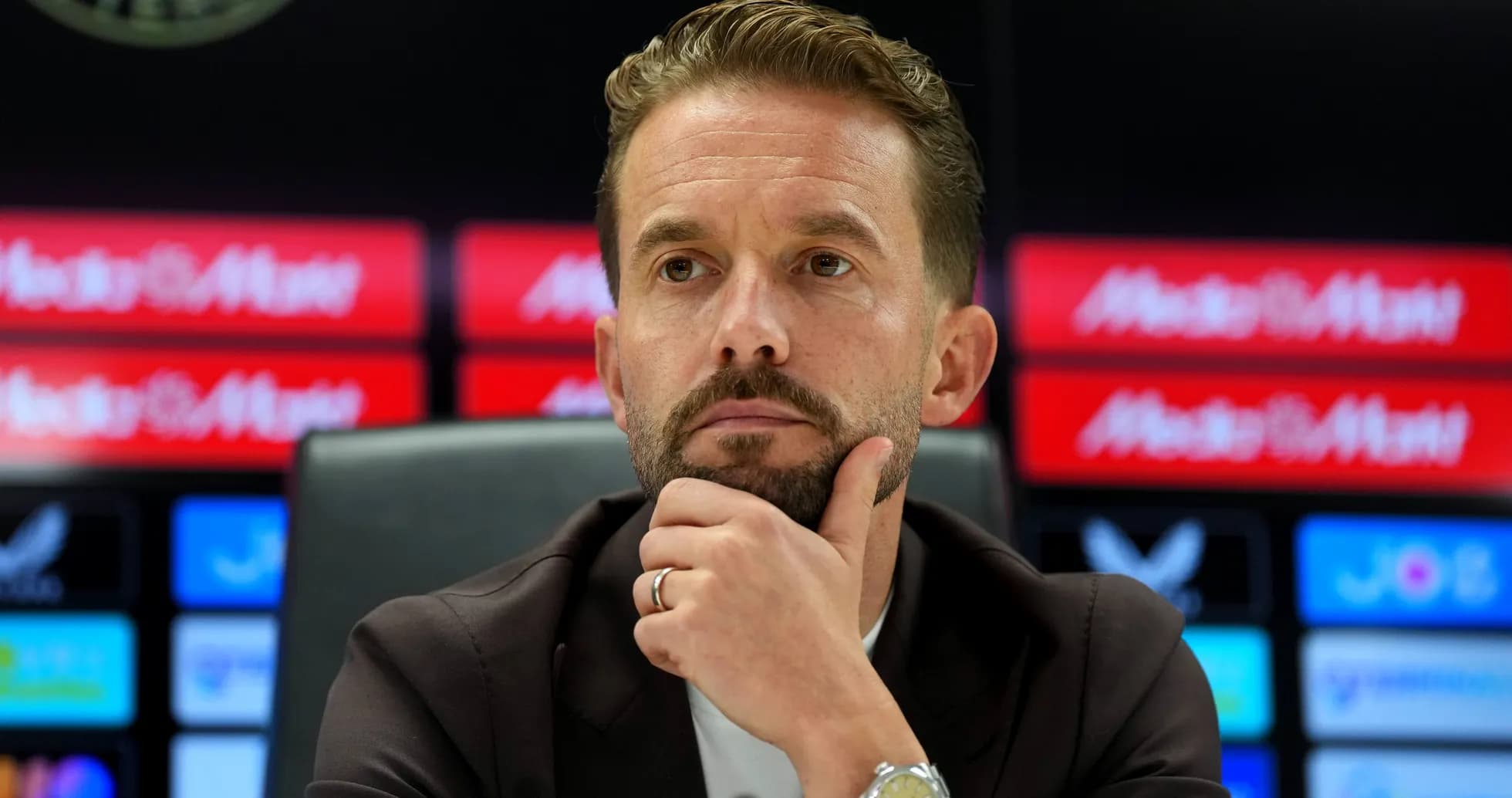 Manager at press conference with thoughtful expression