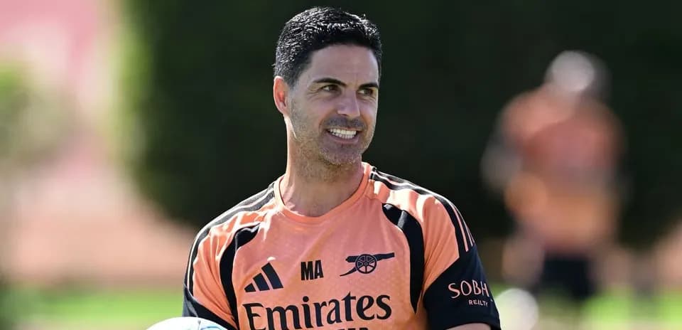 Arsenal manager holding a football during training