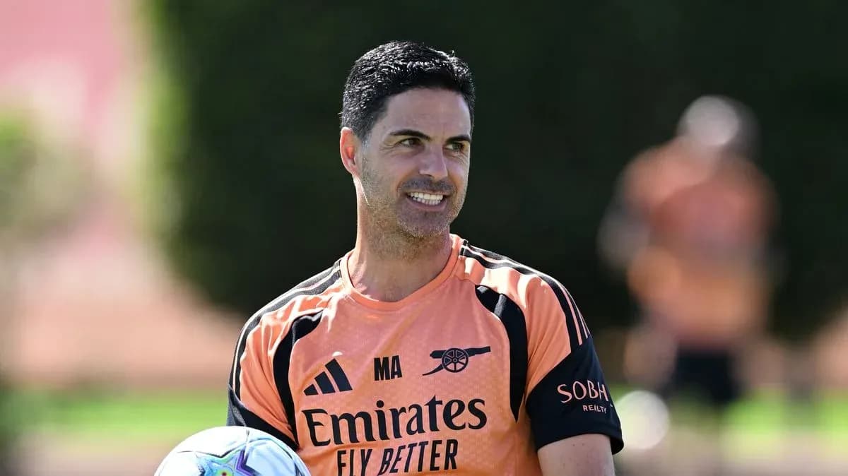 Arsenal manager holding a football during training