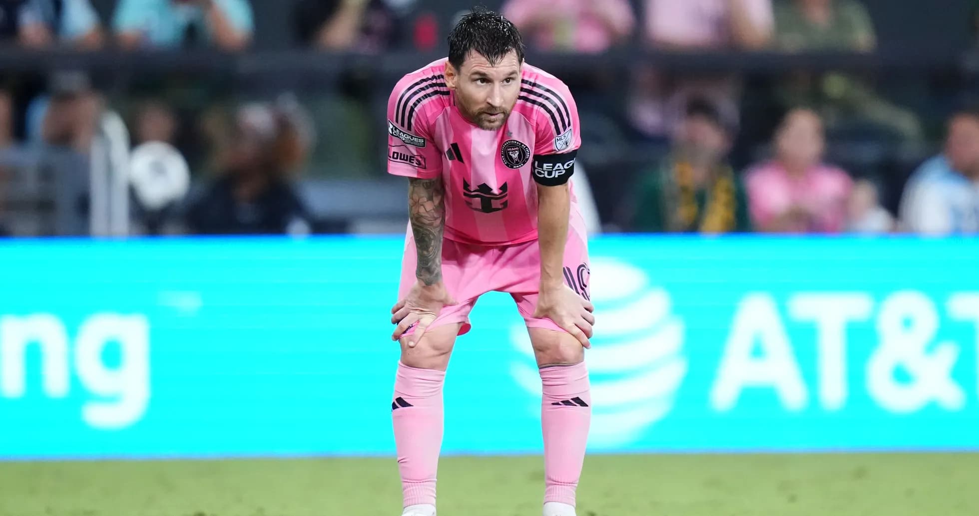 Player in pink uniform during match, hands on knees