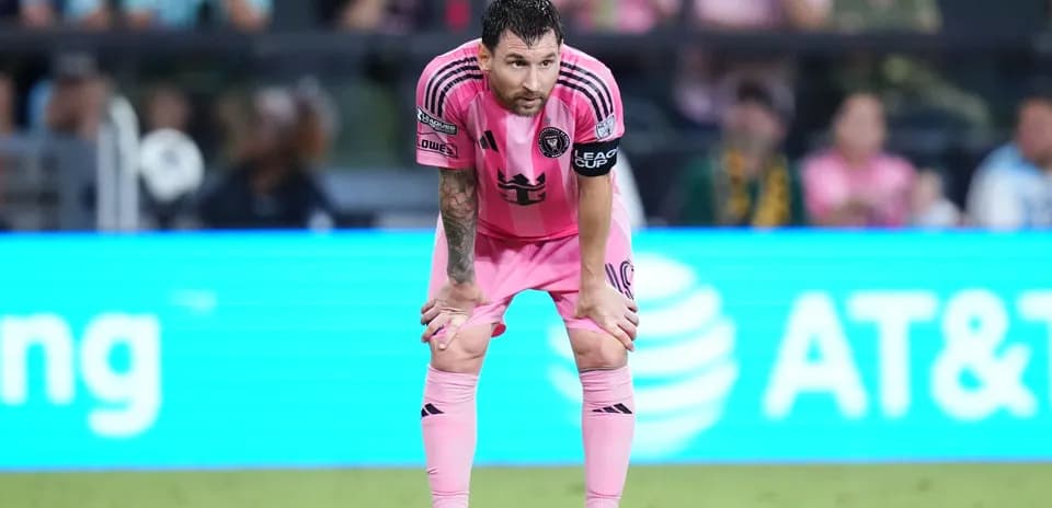 Player in pink uniform during match, hands on knees