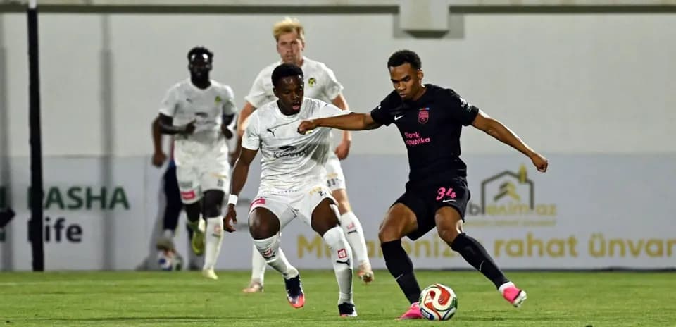 Player in black jersey dribbling past opponent