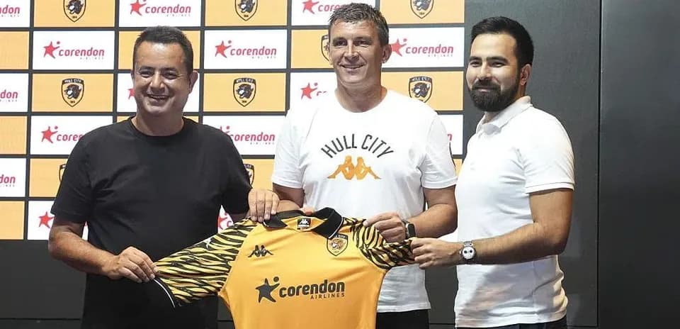 New manager holding Hull City jersey at unveiling