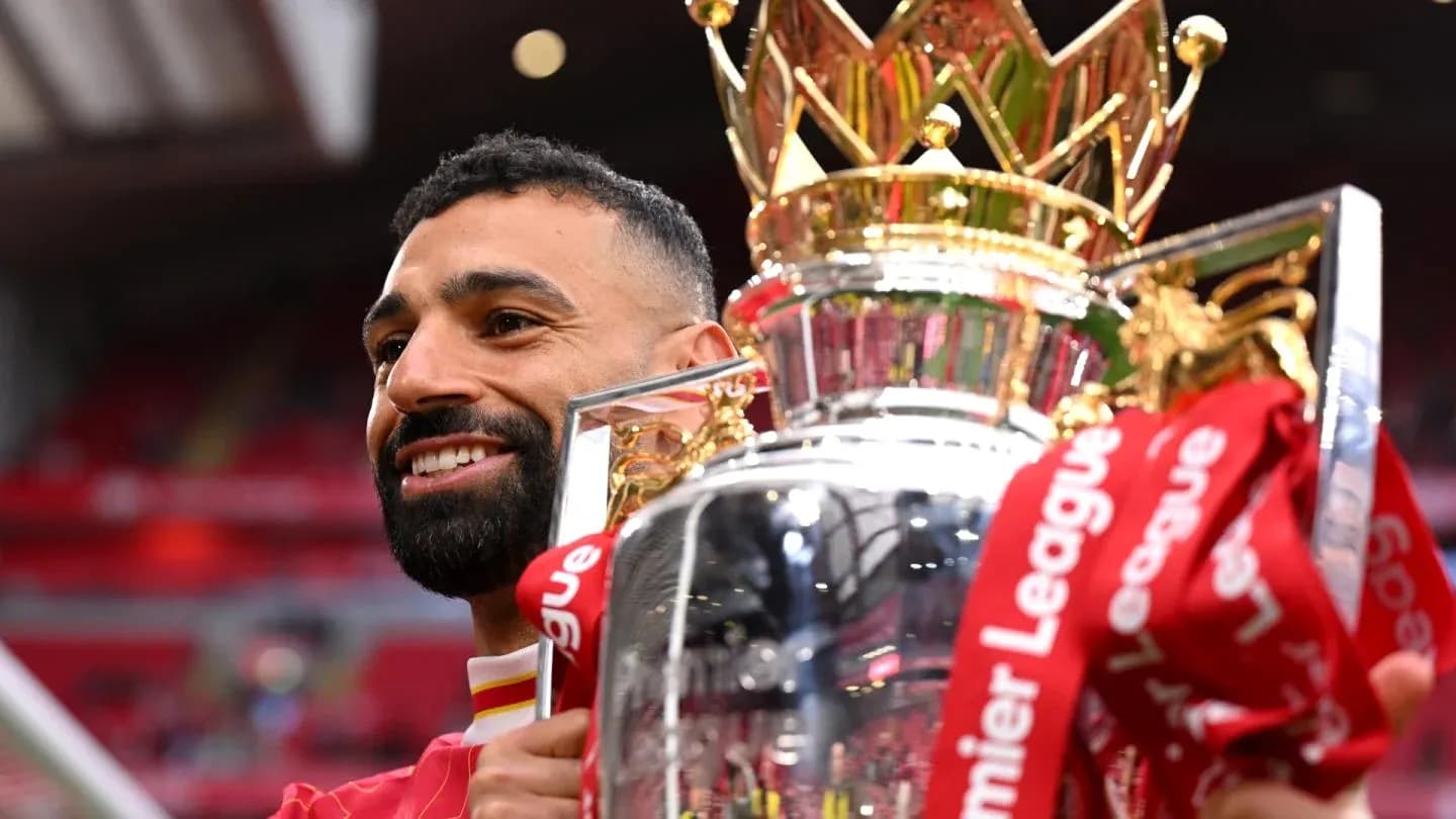 Player holding Premier League trophy in celebration