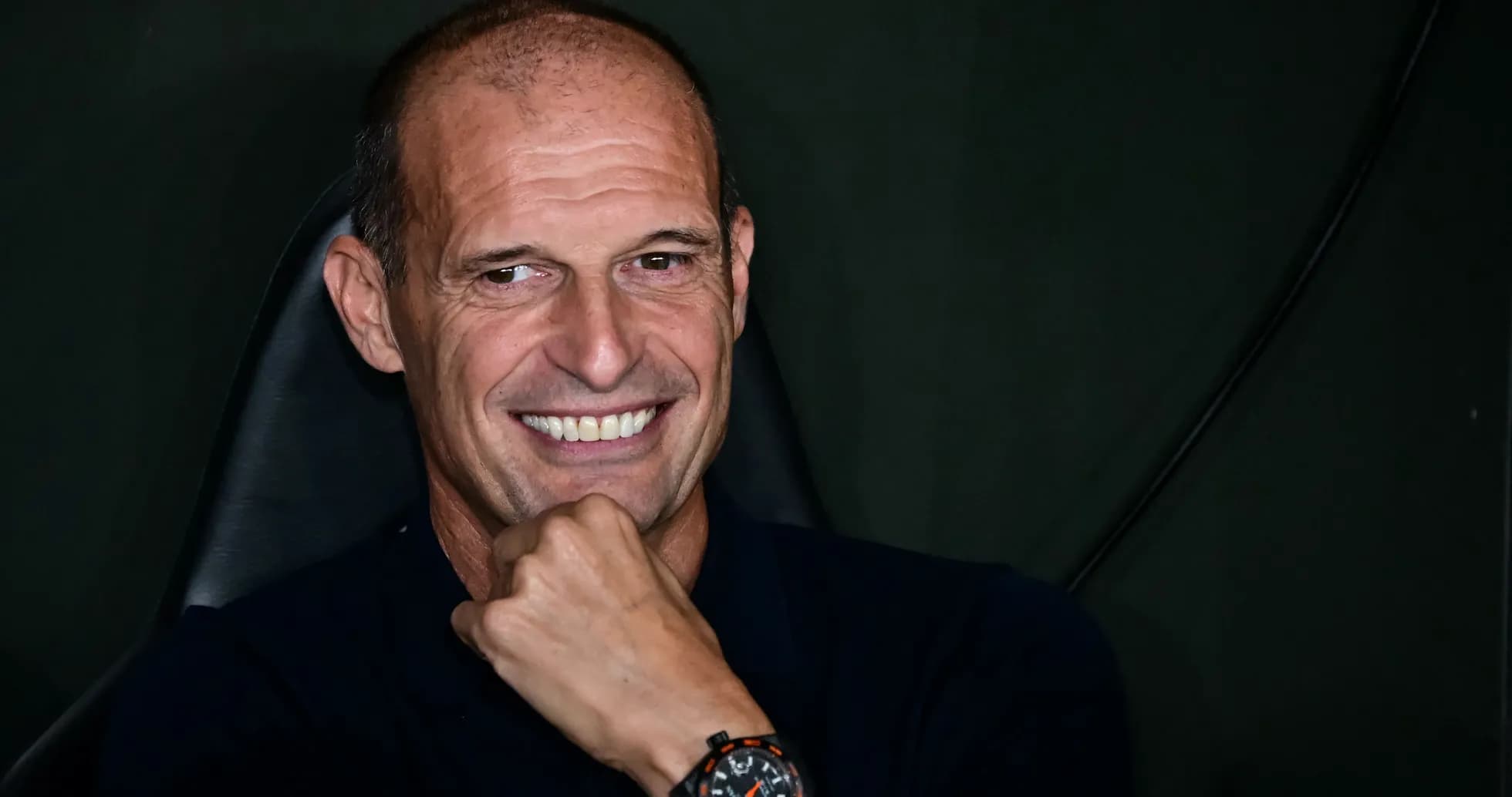 Coach smiling while sitting in a chair
