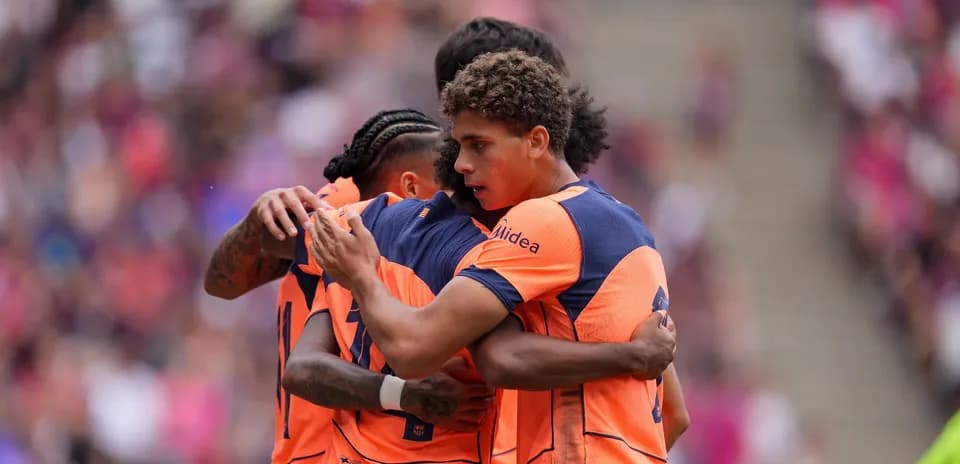 Players celebrating a goal in team jerseys