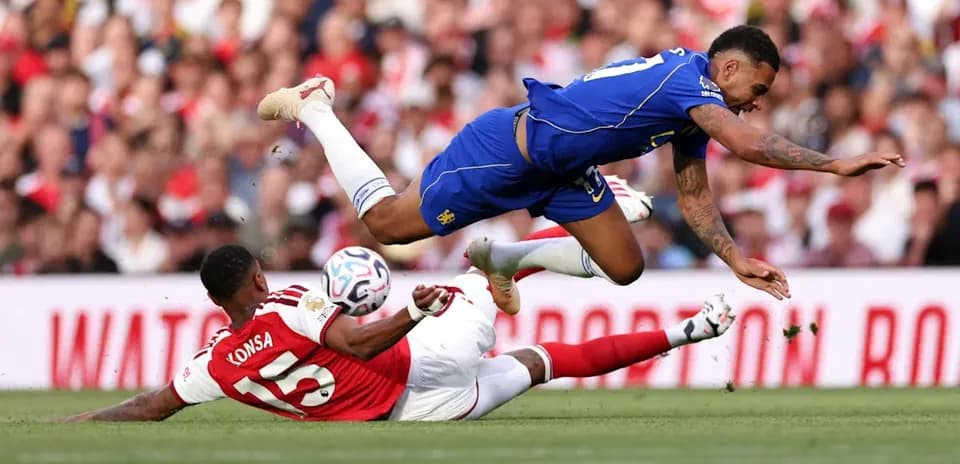 Player tackling another during football match action