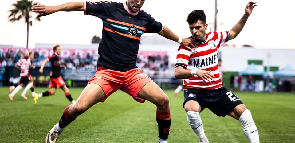 Players competing for the ball in USL match
