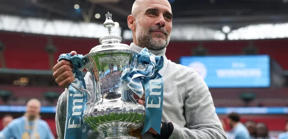 Coach holding trophy at Wembley after victory