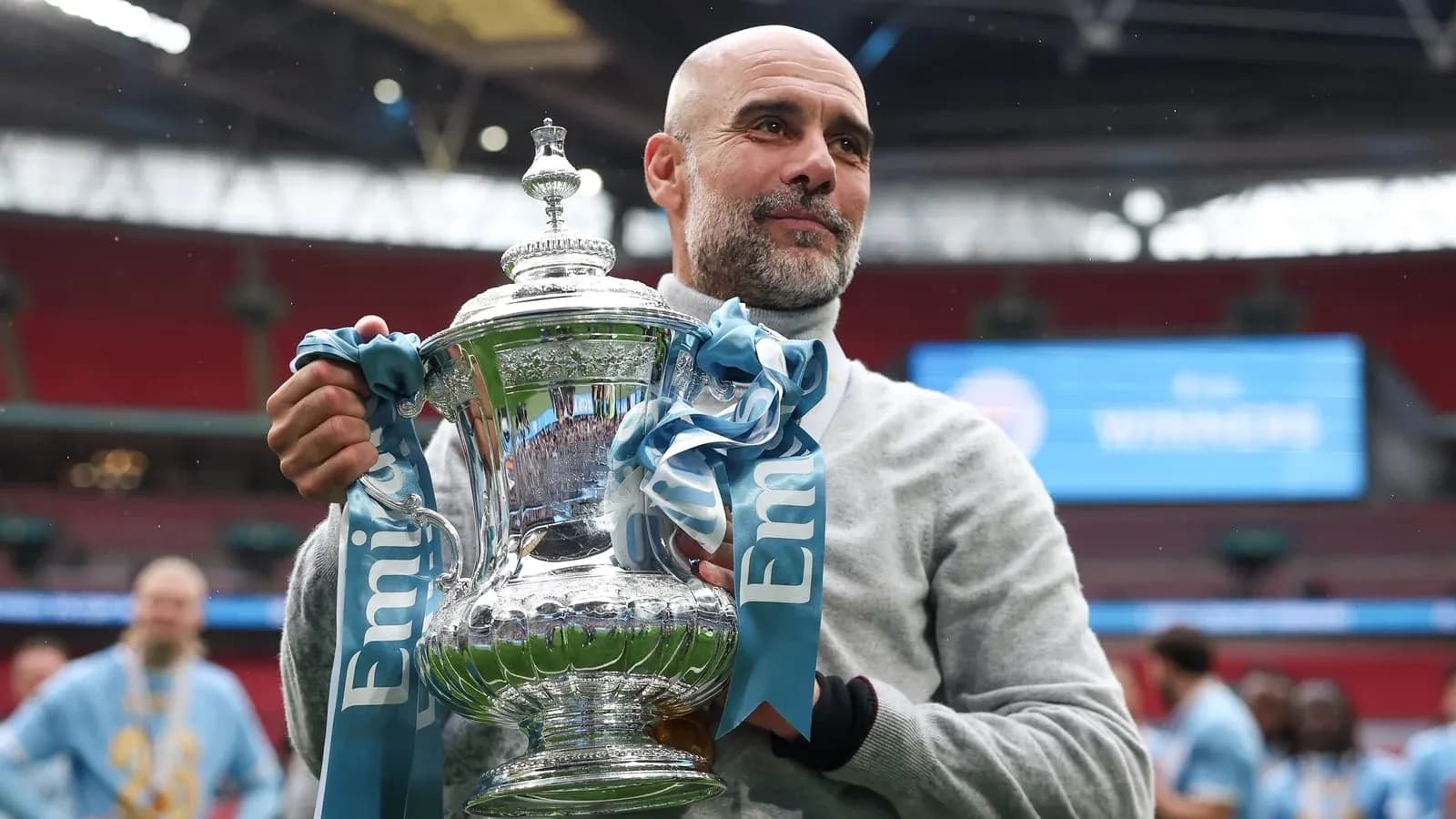 Coach holding trophy at Wembley after victory