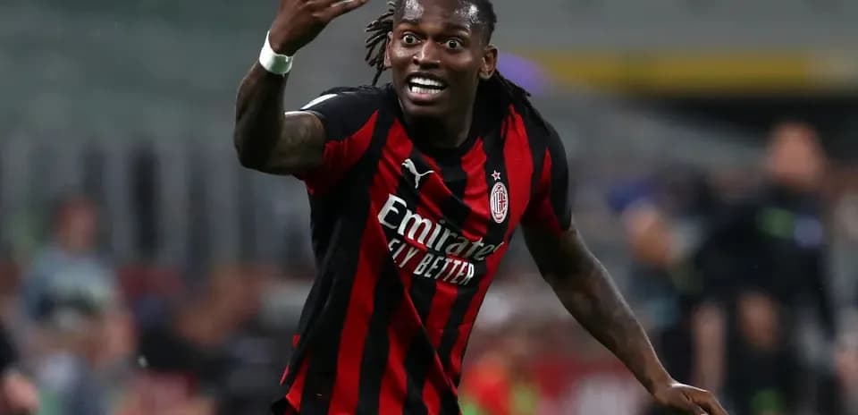 Player gesturing during a match wearing AC Milan jersey