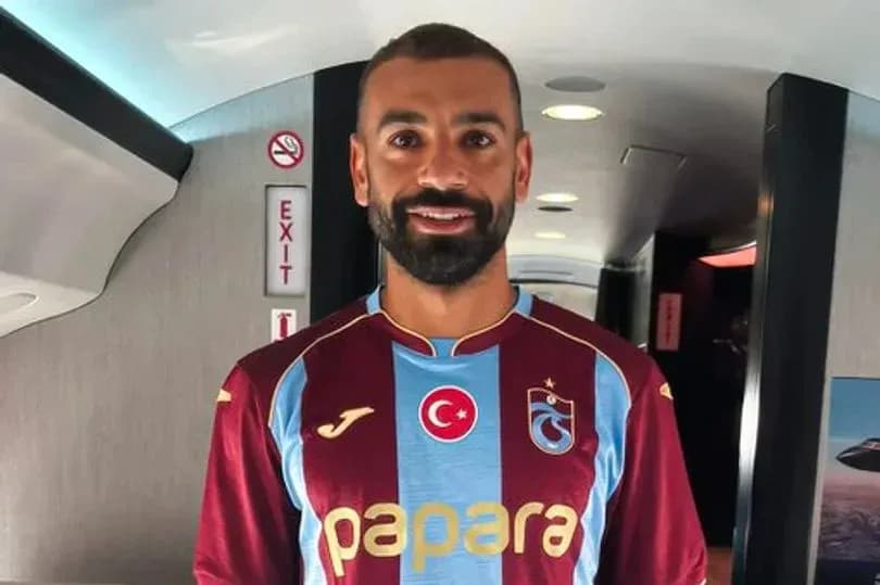 Player wearing Trabzonspor jersey inside airplane