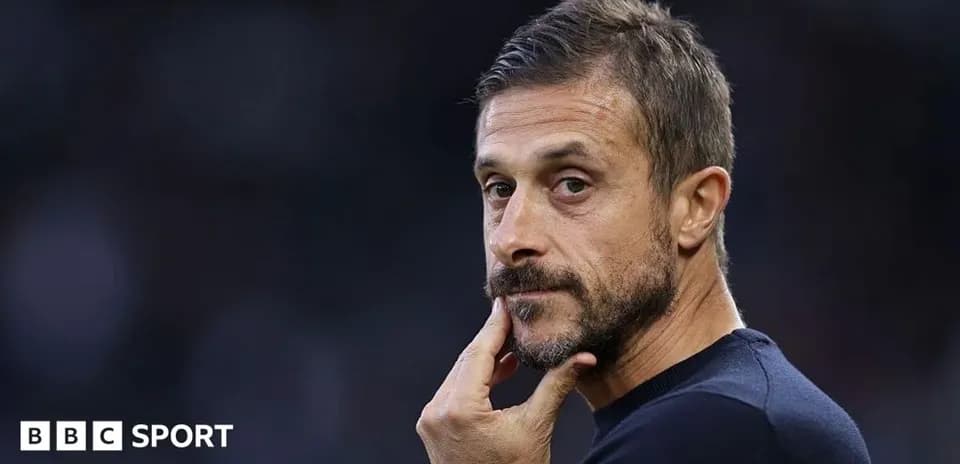 Coach pondering during match, hand on chin