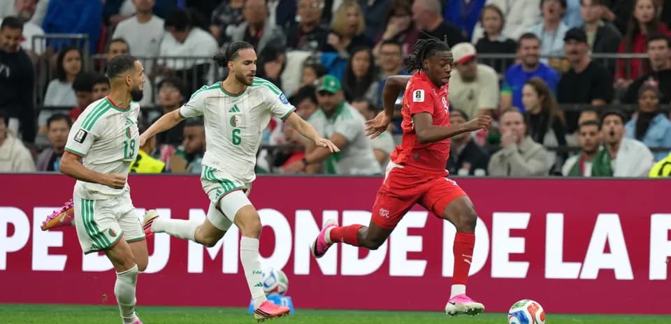Switzerland player sprinting past Algeria defenders