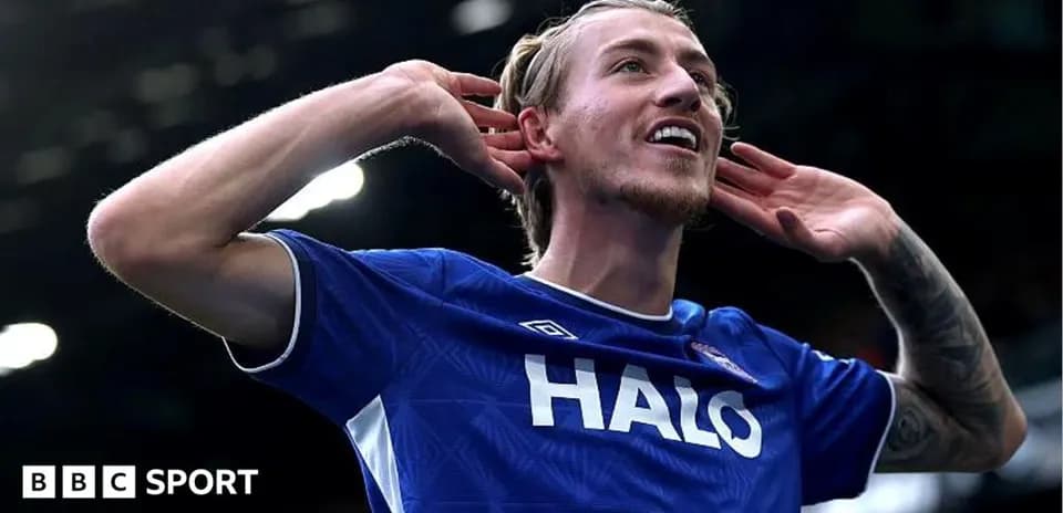 Player celebrating with hands to ears after scoring