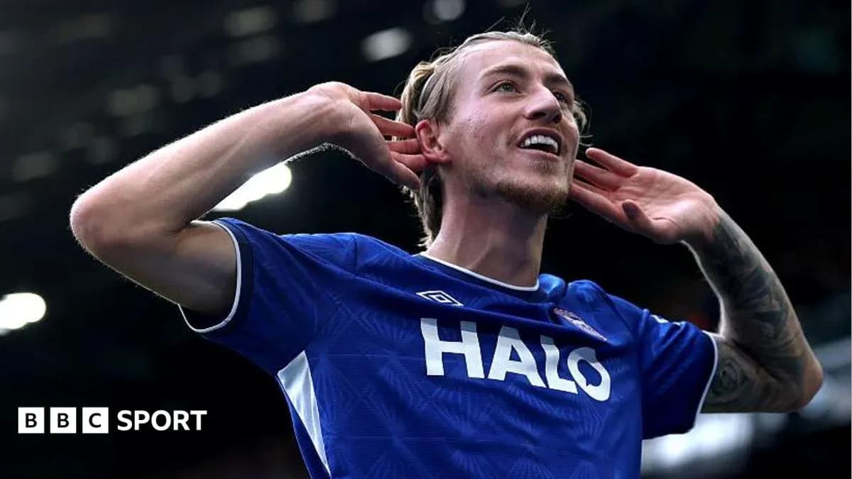 Player celebrating with hands to ears after scoring