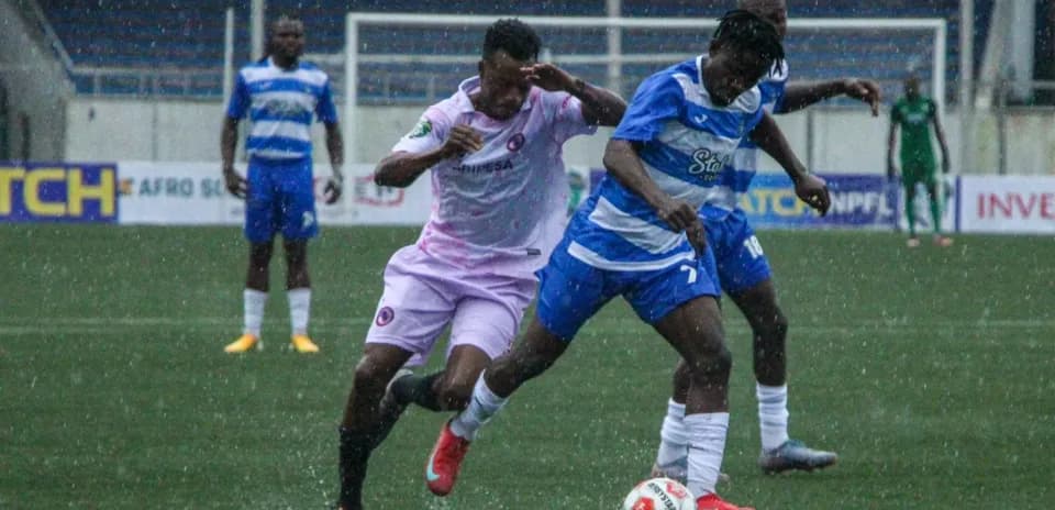 Players competing for the ball in rainy match